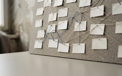 Thin threads branching between pinned cards on a board, one thread blue.